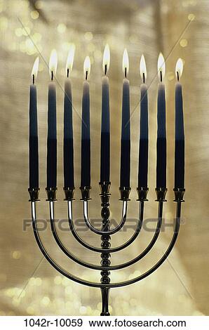 Stock Photo - Lit candles on a menorah. Fotosearch