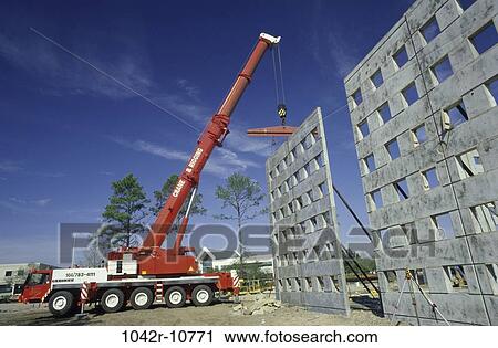 Low angle view of a crane carrying a section of a building View Large Photo Image Stock Image - Low angle view of a crane carrying a section of a building. Fotosearch