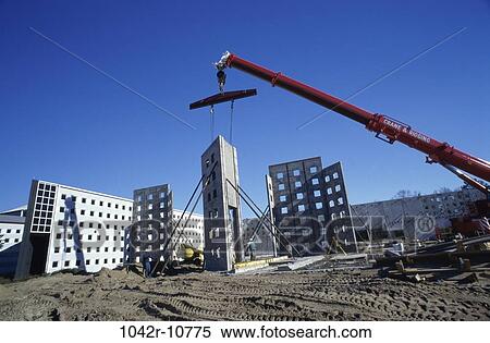 Stock Photography - Low angle view of a crane carrying a section of a building. Fotosearch