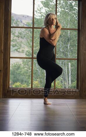 Low angle view of a senior woman standing on one leg exercising View Large Photo Image Stock Photo - Low angle view of a senior woman standing on one leg exercising. Fotosearch