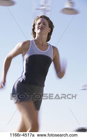 Low angle view of a woman running View Large Photo Image Stock Image - Low angle view of a woman running. Fotosearch