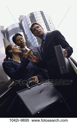 Low angle view of business executives standing together View Large Photo Image Stock Photography - Low angle view of business executives standing together. Fotosearch