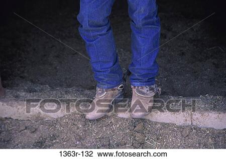 Stock Image - Low section view of a person wearing cowboy boots. Fotosearch