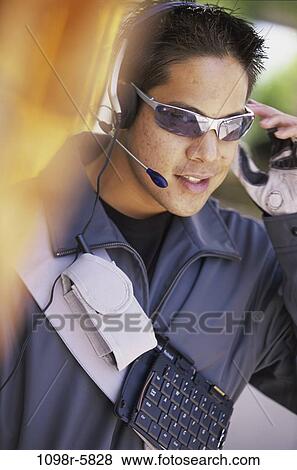 Stock Photo - Male messenger talking on a mobile phone. Fotosearch