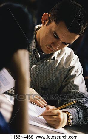 Male student writing during an examination View Large Photo Image Stock Photo - Male student writing during an examination. Fotosearch