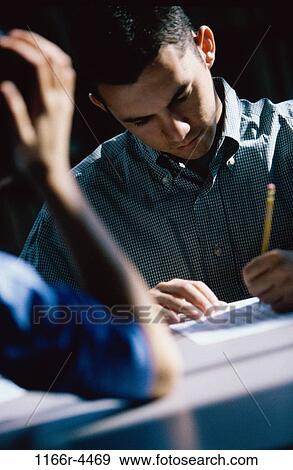 Stock Photo - Male student writing during an examination. Fotosearch