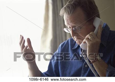 Stock Photograph - Mature man talking on a telephone. Fotosearch