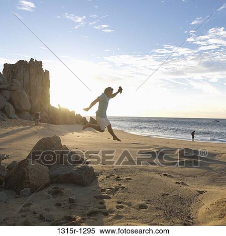 Mexico, Baja California, Los Cabos, man jumping between boulders above edge of sea View Large Photo Image Stock Photography - Mexico, Baja California, Los Cabos, man jumping between boulders above edge of sea. Fotosearch
