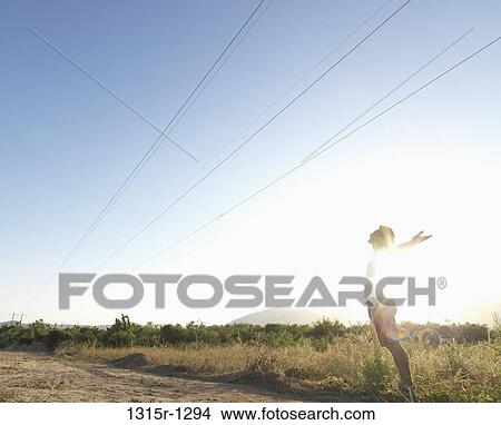 Mexico, Baja California, Man standing under power lines in desert with arms outstretched View Large Photo Image Picture - Mexico, Baja California, Man standing under power lines in desert with arms outstretched. Fotosearch