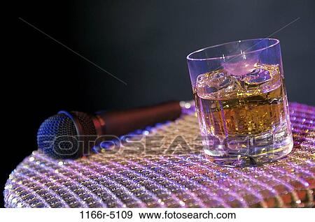 Microphone and a glass of whisky on a stool View Large Photo Image Stock Photo - Microphone and a glass of whisky on a stool. Fotosearch