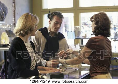 Mid adult couple shopping in a jewelry store View Large Photo Image Stock Photo - Mid adult couple shopping in a jewelry store. Fotosearch
