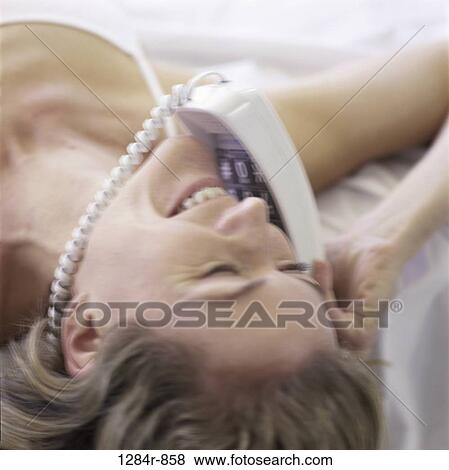 Mid adult woman lying down talking on a telephone View Large Photo Image Stock Photo - Mid adult woman lying down talking on a telephone. Fotosearch