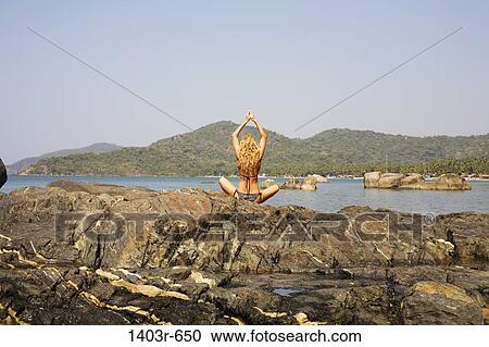 Mid adult woman meditating on a rock, Palolem Beach, Goa, India View Large Photo Image Stock Image - Mid adult woman meditating on a rock, Palolem Beach, Goa, India. Fotosearch