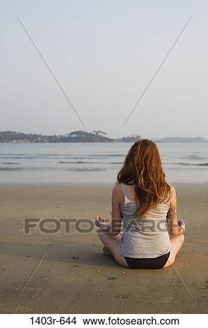 Mid adult woman meditating on the beach, Palolem Beach, Goa, India View Large Photo Image Picture - Mid adult woman meditating on the beach, Palolem Beach, Goa, India. Fotosearch