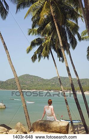Mid adult woman sitting on a rock, Palolem Beach, Goa, India View Large Photo Image Stock Photo - Mid adult woman sitting on a rock, Palolem Beach, Goa, India. Fotosearch