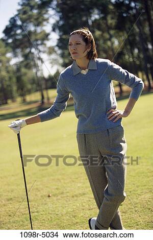 Mid adult woman standing on a golf course View Large Photo Image Picture - Mid adult woman standing on a golf course. Fotosearch