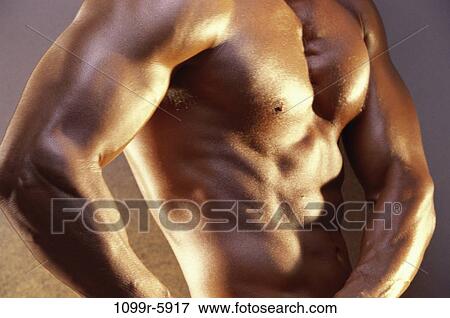 Stock Photo - Mid section view of a young man flexing his muscles. Fotosearch