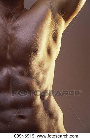 Mid section view of a young man flexing his muscles View Large Photo Image Stock Photo - Mid section view of a young man flexing his muscles. Fotosearch