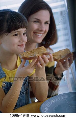 Mother and daughter holding slices of bread View Large Photo Image Stock Photograph - Mother and daughter holding slices of bread. Fotosearch