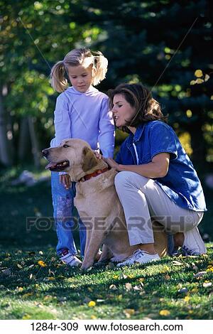 Mother and daughter playing with their pet dog View Large Photo Image Stock Photo - Mother and daughter playing with their pet dog. Fotosearch