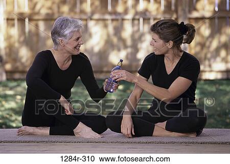 Stock Image - Mother and her daughter sitting together. Fotosearch