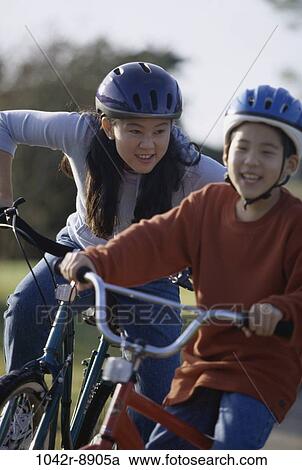 Mother and son riding bicycles together View Large Photo Image Stock Image - Mother and son riding bicycles together. Fotosearch
