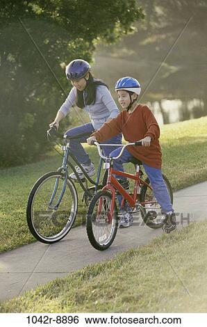 Mother and son riding bicycles together View Large Photo Image Stock Photograph - Mother and son riding bicycles together. Fotosearch