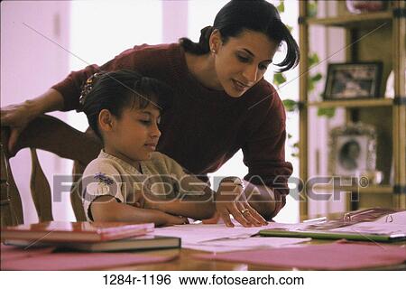 Mother assisting her daughter with her homework View Large Photo Image Stock Photograph - Mother assisting her daughter with her homework. Fotosearch