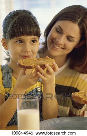 Mother sitting and eating with her daughter View Large Photo Image Stock Photography - Mother sitting and eating with her daughter. Fotosearch