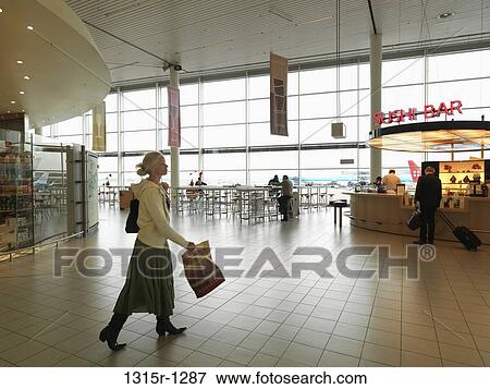 Netherlands, Amsterdam, Schipol airport, woman walking across departure lounge View Large Photo Image Stock Photo - Netherlands, Amsterdam, Schipol airport, woman walking across departure lounge. Fotosearch