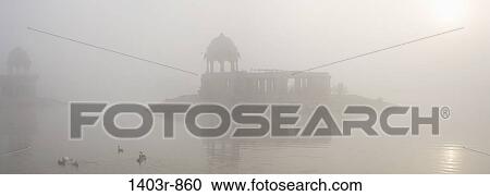 Panoramic view of a foggy sunrise at Lake Gadisar in Jaisalmer, India in Rajasthan state View Large Photo Image Stock Image - Panoramic view of a foggy sunrise at Lake Gadisar in Jaisalmer, India in Rajasthan state. Fotosearch