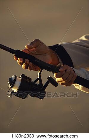 Stock Image - Person holding a fishing rod. Fotosearch