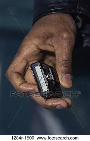 Person holding a pager View Large Photo Image Stock Image - Person holding a pager. Fotosearch