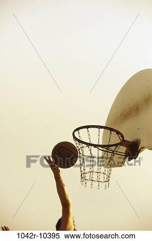 Person's hand holding a basketball near the hoop View Large Photo Image Stock Photography - Person's hand holding a basketball near the hoop. Fotosearch