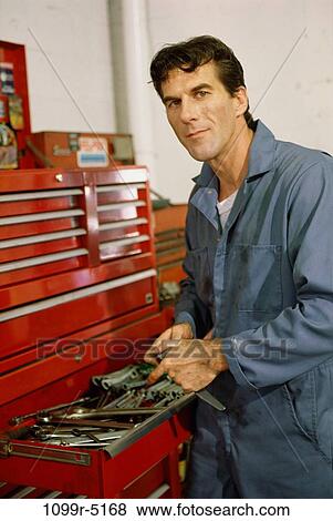 Portrait of a auto mechanic standing at a toolbox in a garage View Large Photo Image Stock Photo - Portrait of a auto mechanic standing at a toolbox in a garage. Fotosearch