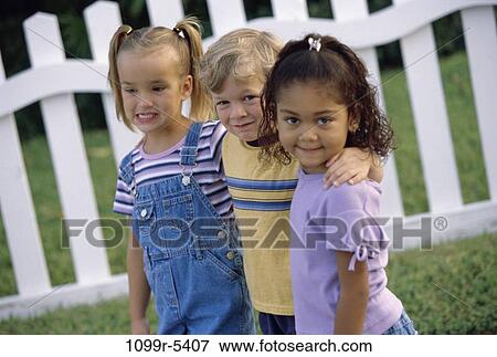 Portrait of a boy and two girls standing together View Large Photo Image Stock Photo - Portrait of a boy and two girls standing together. Fotosearch