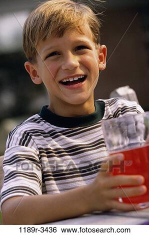 Portrait of a boy holding a glass of juice View Large Photo Image Stock Photograph - Portrait of a boy holding a glass of juice. Fotosearch
