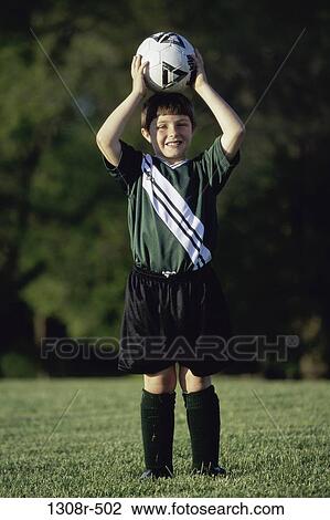 Portrait of a boy holding a soccer ball above his head View Large Photo Image Stock Image - Portrait of a boy holding a soccer ball above his head. Fotosearch