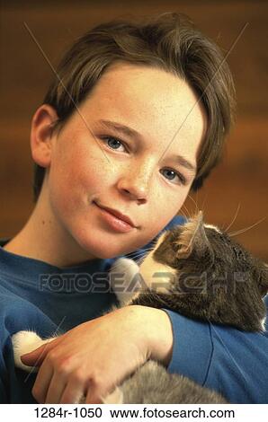 Stock Image - Portrait of a boy hugging a cat. Fotosearch