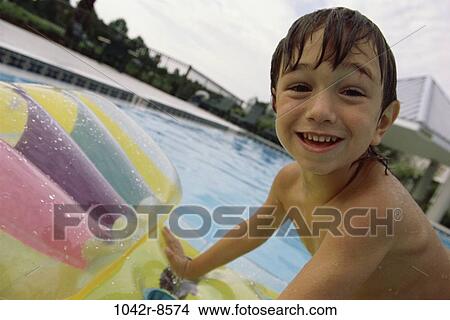 Picture - Portrait of a boy on a raft in a swimming pool. Fotosearch