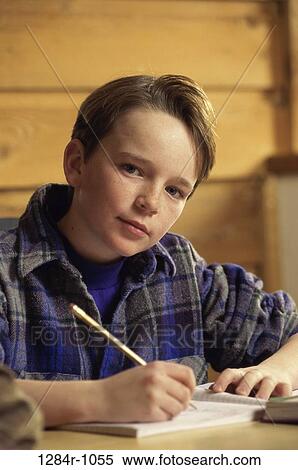Stock Photography - Portrait of a boy sitting at a desk studying. Fotosearch