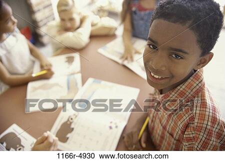 Portrait of a boy smiling in a classroom View Large Photo Image Stock Image - Portrait of a boy smiling in a classroom. Fotosearch