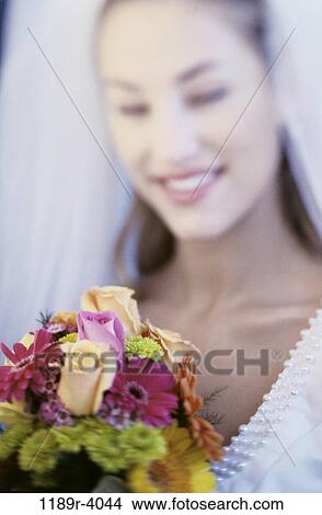 Picture - Portrait of a bride smiling holding a bouquet of flowers. Fotosearch