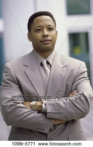 Portrait of a businessman standing with his arms crossed View Large Photo Image Stock Image - Portrait of a businessman standing with his arms crossed. Fotosearch