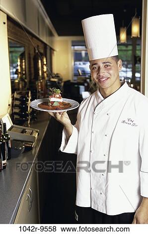 Portrait of a chef holding a plate of food View Large Photo Image Stock Photo - Portrait of a chef holding a plate of food. Fotosearch