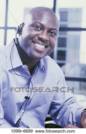 Portrait of a customer service representative smiling View Large Photo Image Stock Photo - Portrait of a customer service representative smiling. Fotosearch