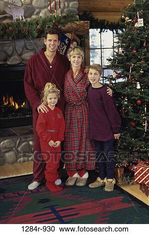Stock Image - Portrait of a family standing near a Christmas tree. Fotosearch