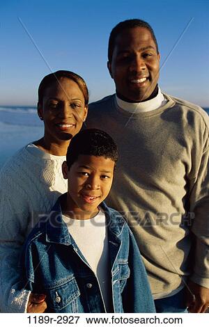 Stock Photo - Portrait of a father and mother with their son on the beach. Fotosearch