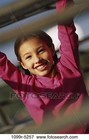 Portrait of a girl hanging on monkey bars View Large Photo Image Stock Photo - Portrait of a girl hanging on monkey bars. Fotosearch