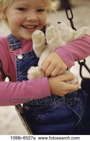 Portrait of a girl holding a teddy bear View Large Photo Image Stock Image - Portrait of a girl holding a teddy bear. Fotosearch